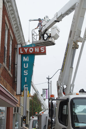 Phantom Neon Signs and Graphics employees prepare to remove the iconic Lyons Music sign from its North Green Street location.